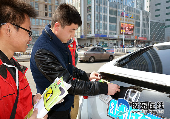 志愿者和车主共同张贴“礼让斑马线”车贴（点击看高清图）